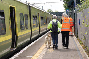 Man with Guide Dog and IR assistant on platform 400x267